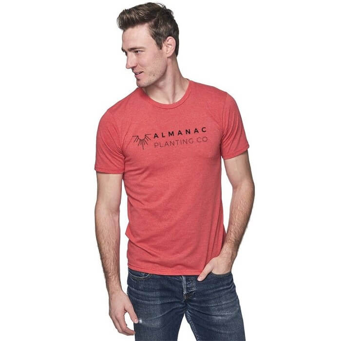 Almanac Planting Co Tee Shirt modeled on a man standing with his head to the side. There is the Almanac Planting Co logo over the chest area of the man.
