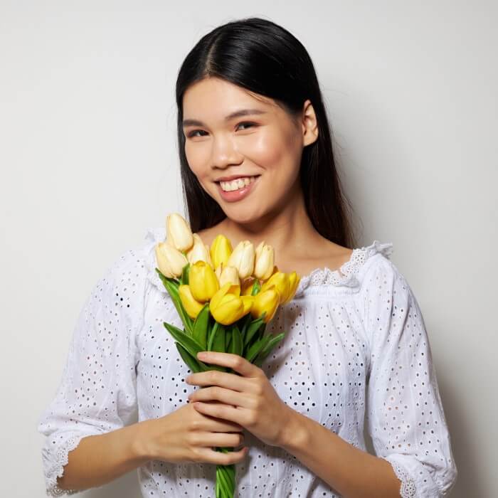 Almanac Planting Co: Outdoor Plants. A woman holding cut yellow flowers.