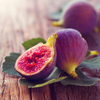 Almanac Planting Co Chicago Hardy Fig Tree (Ficus carica 'Chicago Hardy'). Opened fruit atop a wooden table.