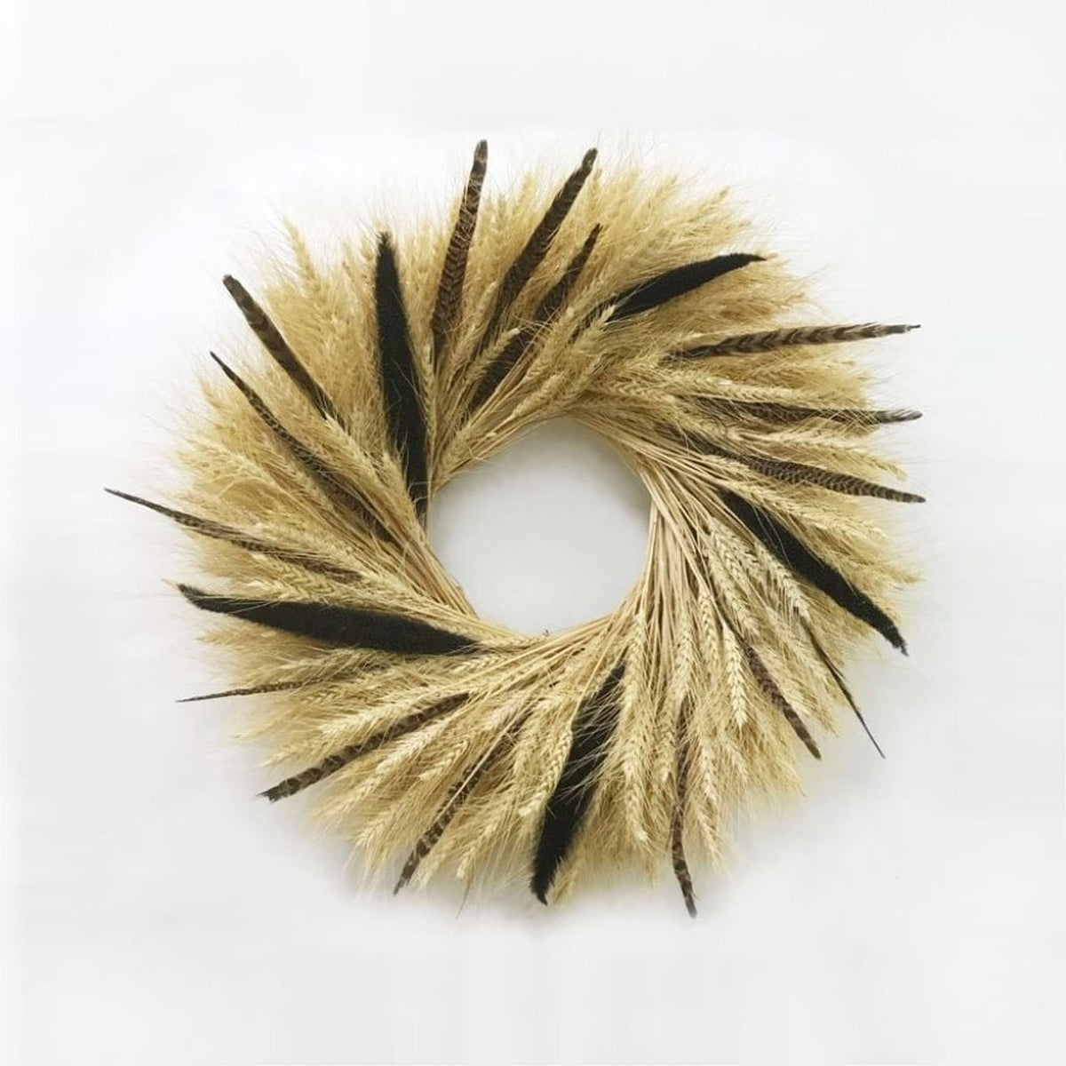 A hand made wreath made out of blonde wheat, majesty millet, and pheasant feathers.