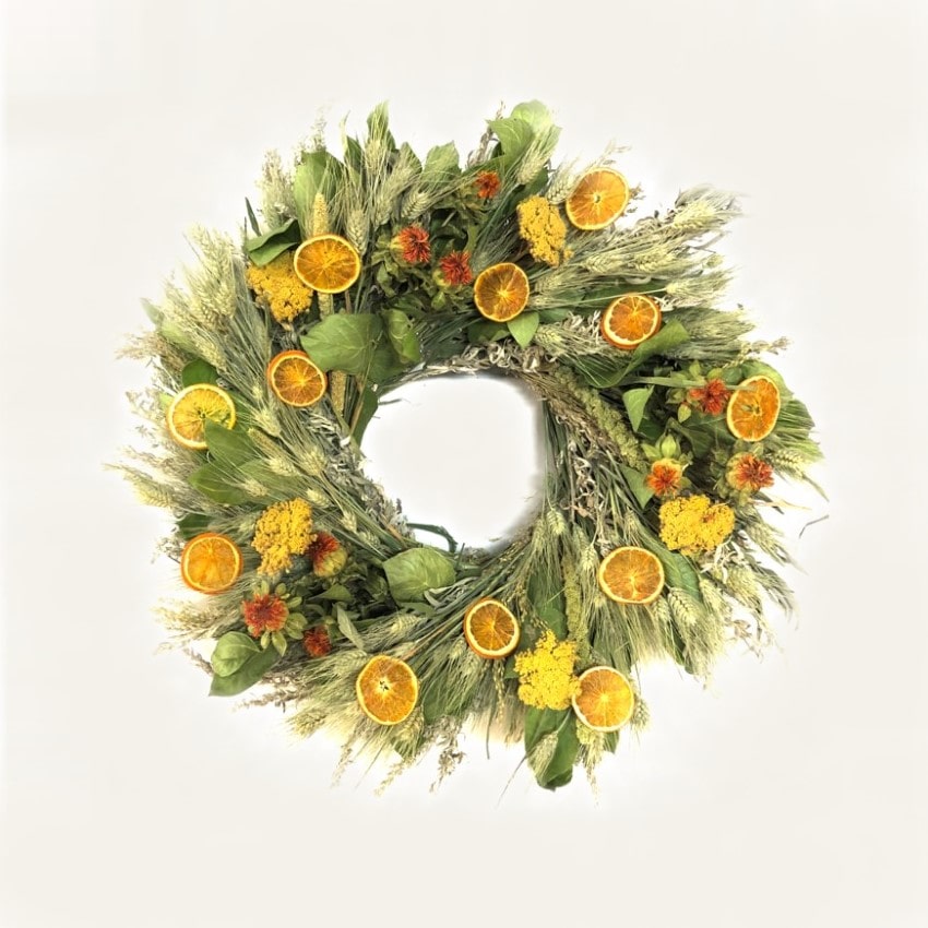 A fresh handmade wreath that's made with air dried salal, green wheat, artemisia, yarrow, China millet, Safflower, prosso millet, and orange slices.