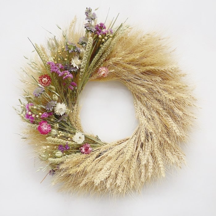 The Strawflower Blonde Wreath. Handmade with: blonde wheat, lemon mint, millet, flax, nigella, sinuata statice, and strawflowers. (A zoomed in image)