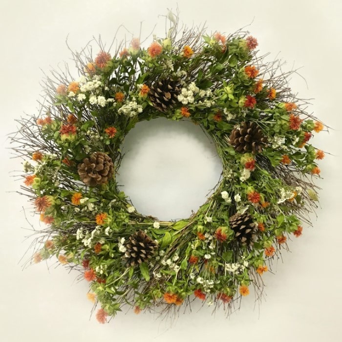 A hand-made fresh wreath with quail brush eggs, safflower, pearly everlasting, and austriaca pine cones.