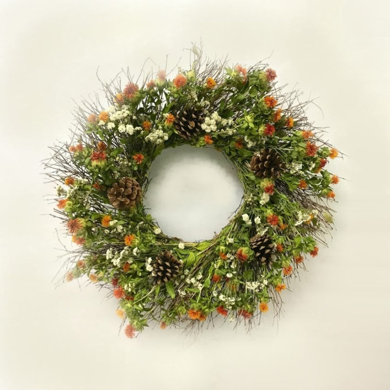 A handmade fresh wreath with quail brush eggs, safflower, pearly everlasting, and austriaca pine cones.